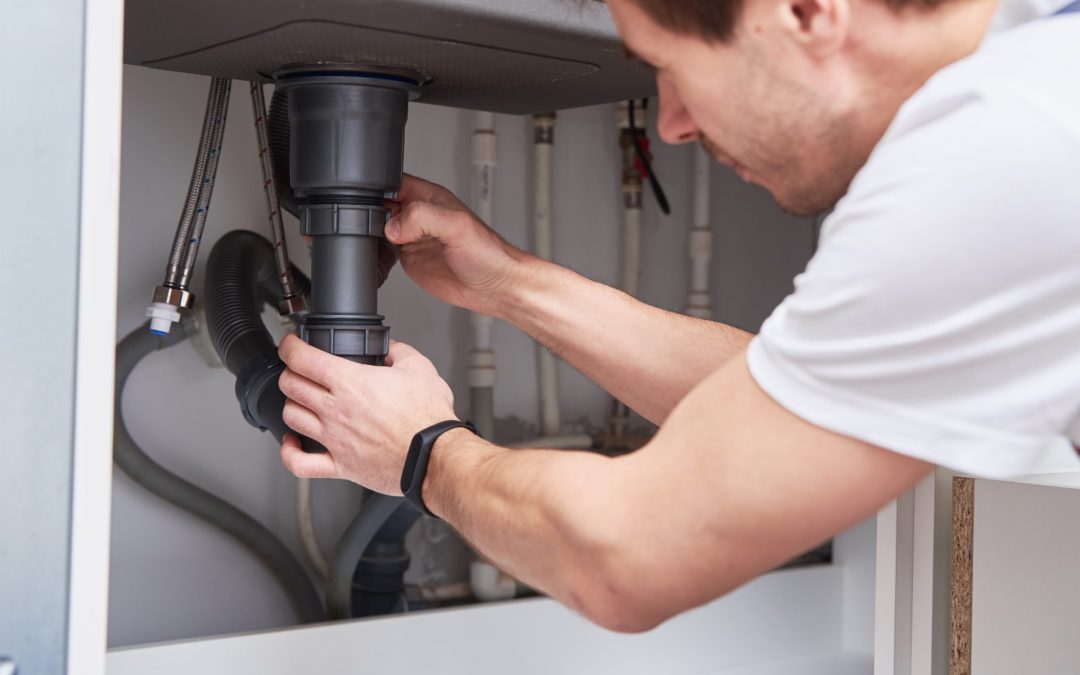 male-plumber-repair-sink-pipe-in-kitchen
